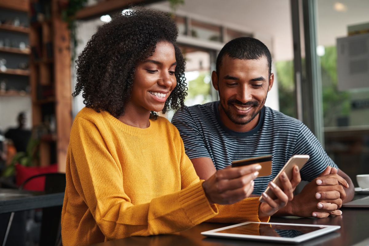 two people order something online, holding credit card and phone